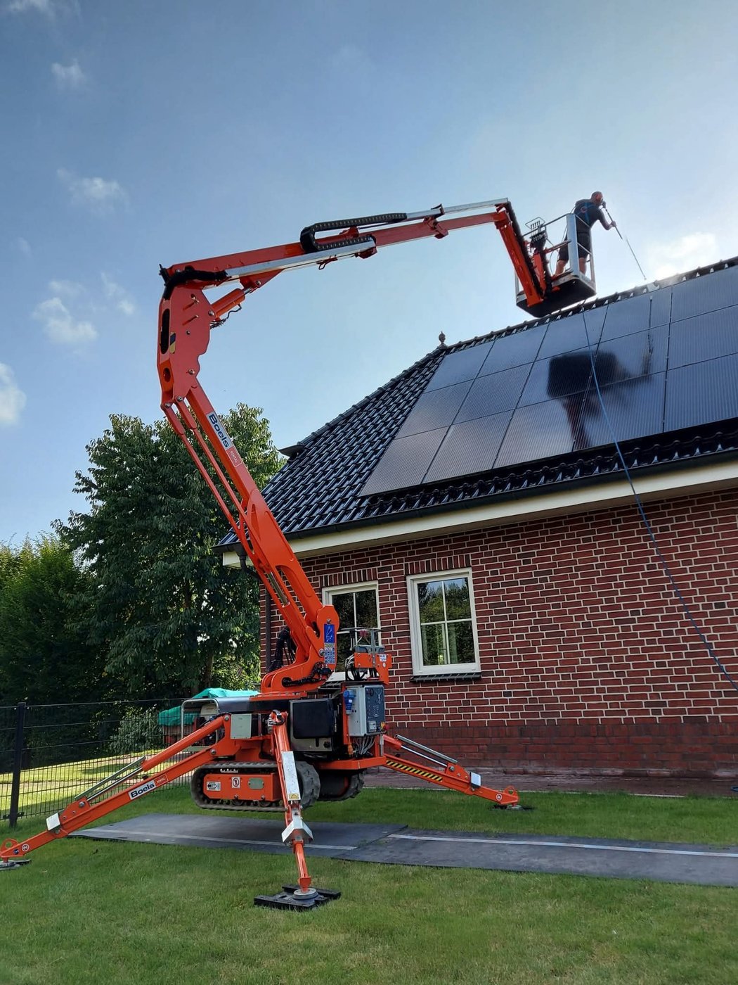 Hoogwerker bij dakreiniging met zonnepanelen